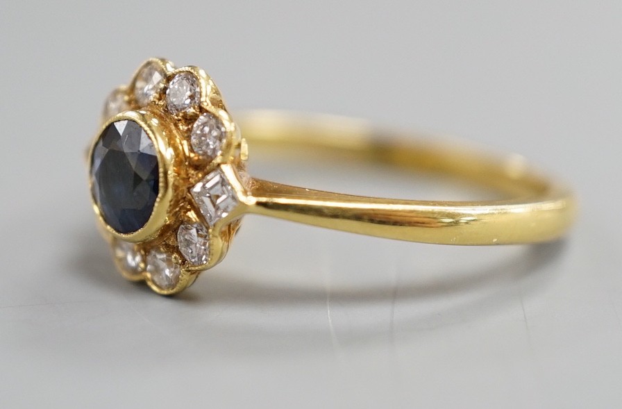 A modern 18ct gold, collet set sapphire and diamond set circular cluster ring, size O, gross weight 3.6 grams